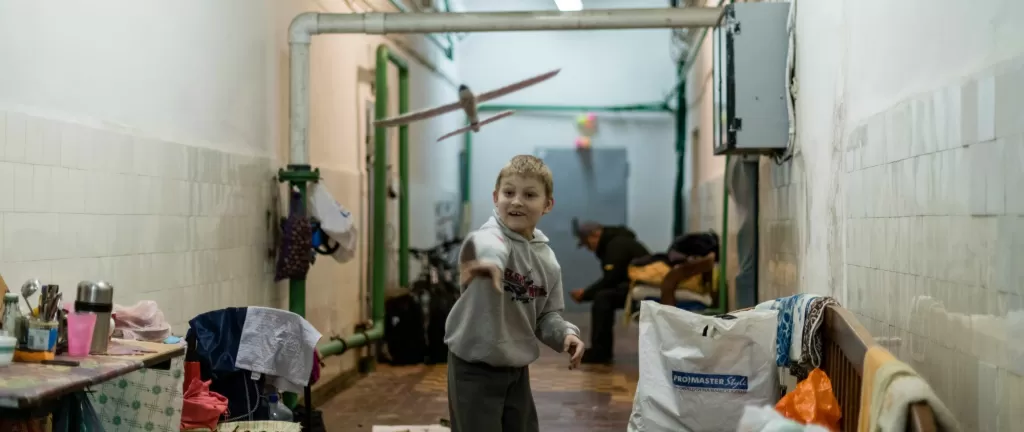 A boy throws a glider in a bomb shelter in Kharkiv