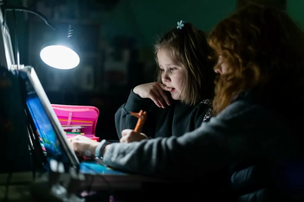 Mavka* helps her daughter, Olesia* with her homework in a public bomb shelter in Kharkiv.